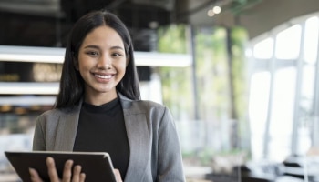 Young professional woman in an office setting holding a tablet