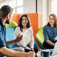 Man sitting and talking with two women
