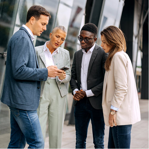 Group of coworkers looking at a phone