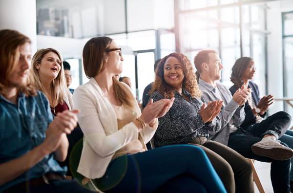 Group of young professionals sitting and clapping