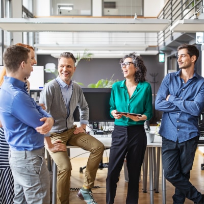 Six business colleagues standing in a lobby talking