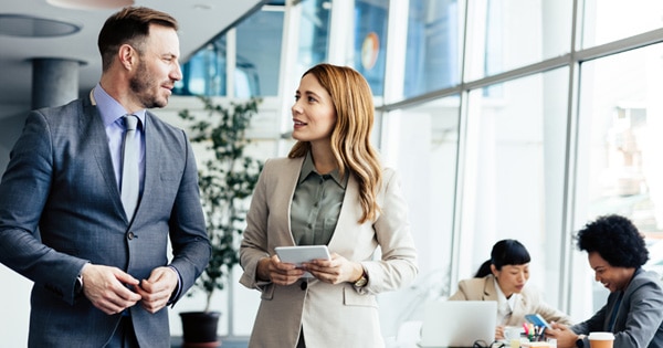 Man and woman talking in an office setting.