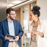 Man and woman walking in an office hallway