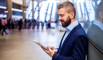 Man looking at his tablet in an airport lobby