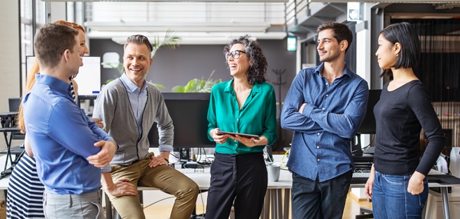Six business colleagues standing in a lobby talking