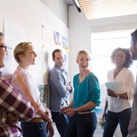 A group of people standing in an office laughing