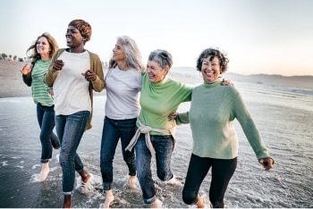 Group of women walking in the shallow surf on the beach